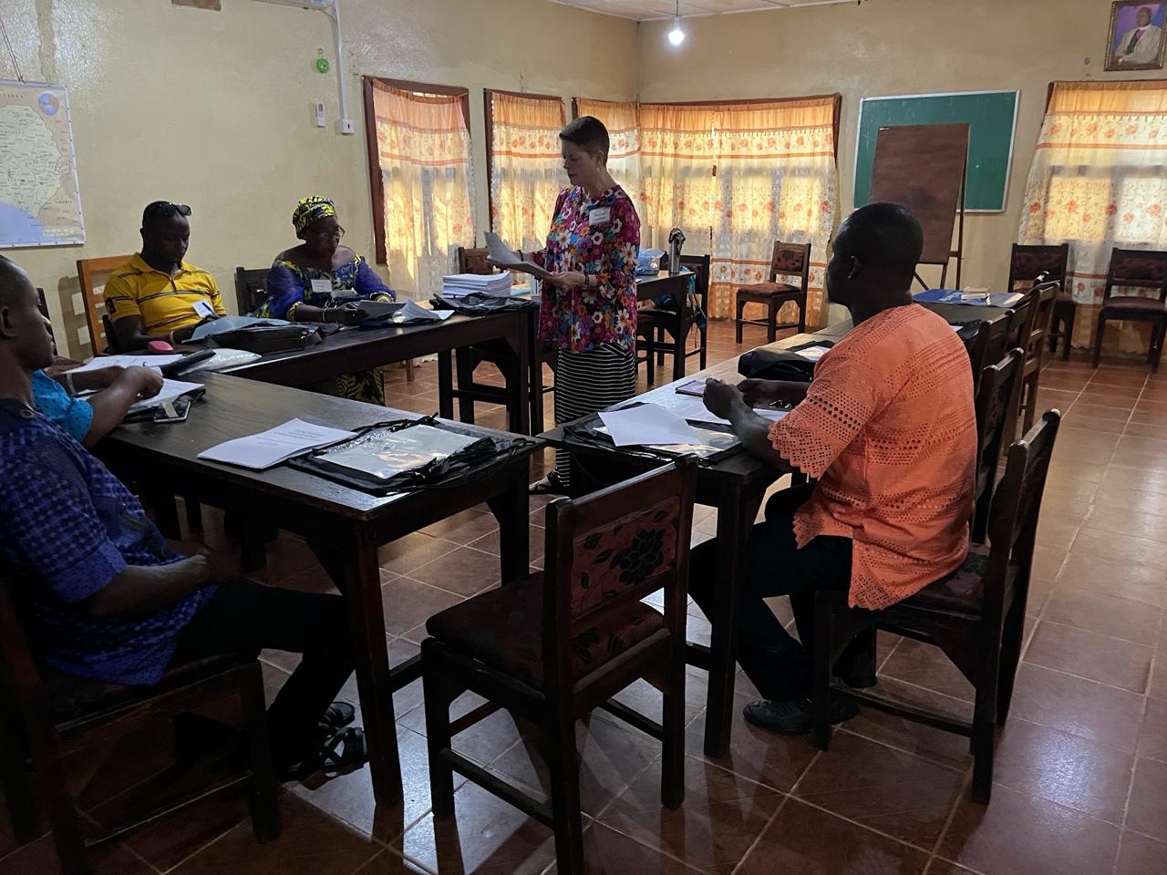 Teacher teaching students sitting at desk