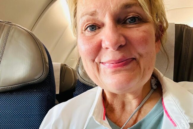 Rev. Gina sitting on airplane.