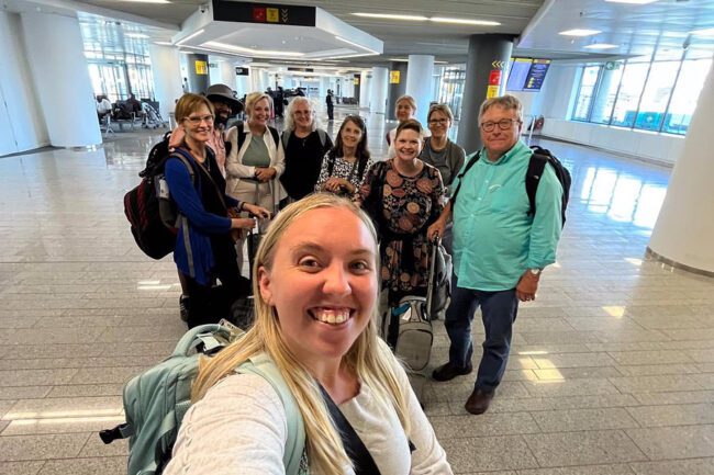 Cassie Robertson taking group picture in airport.